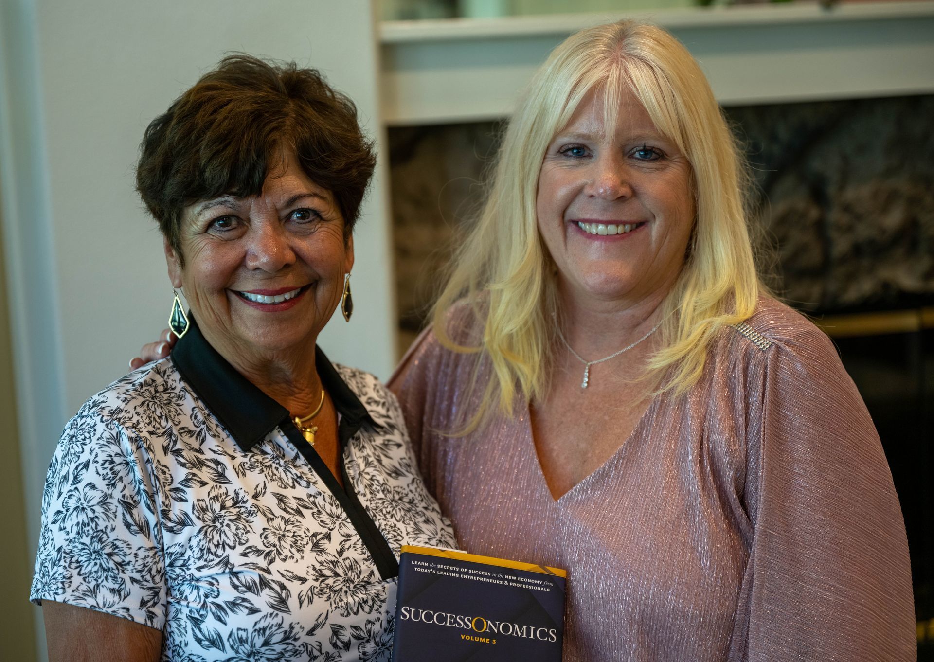 Kim Silverman is standing next to a woman and smiling while holding a book.