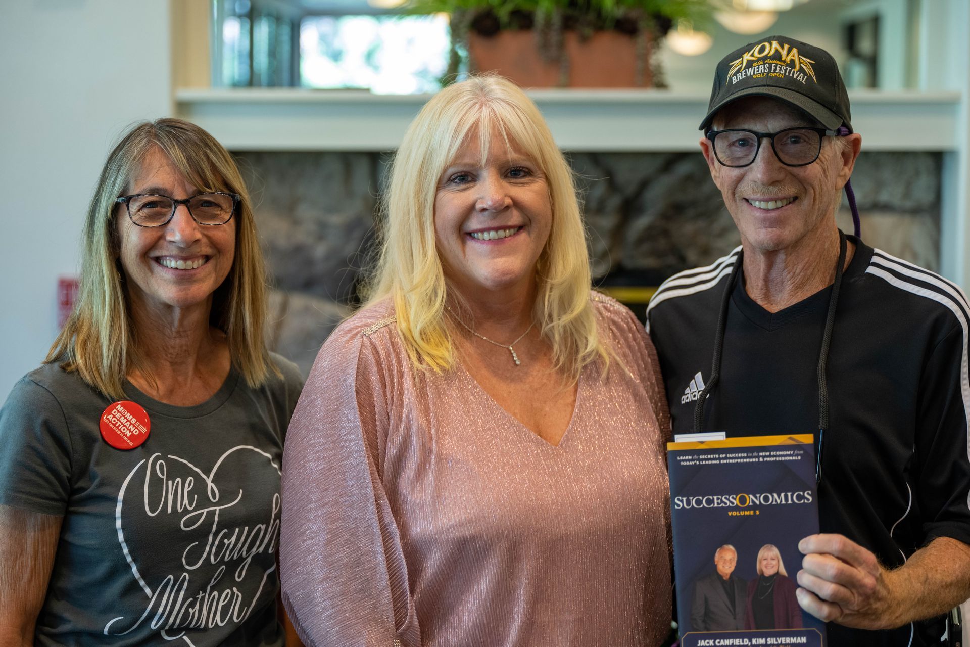 A man and women are standing next Kim Silverman holding a book.