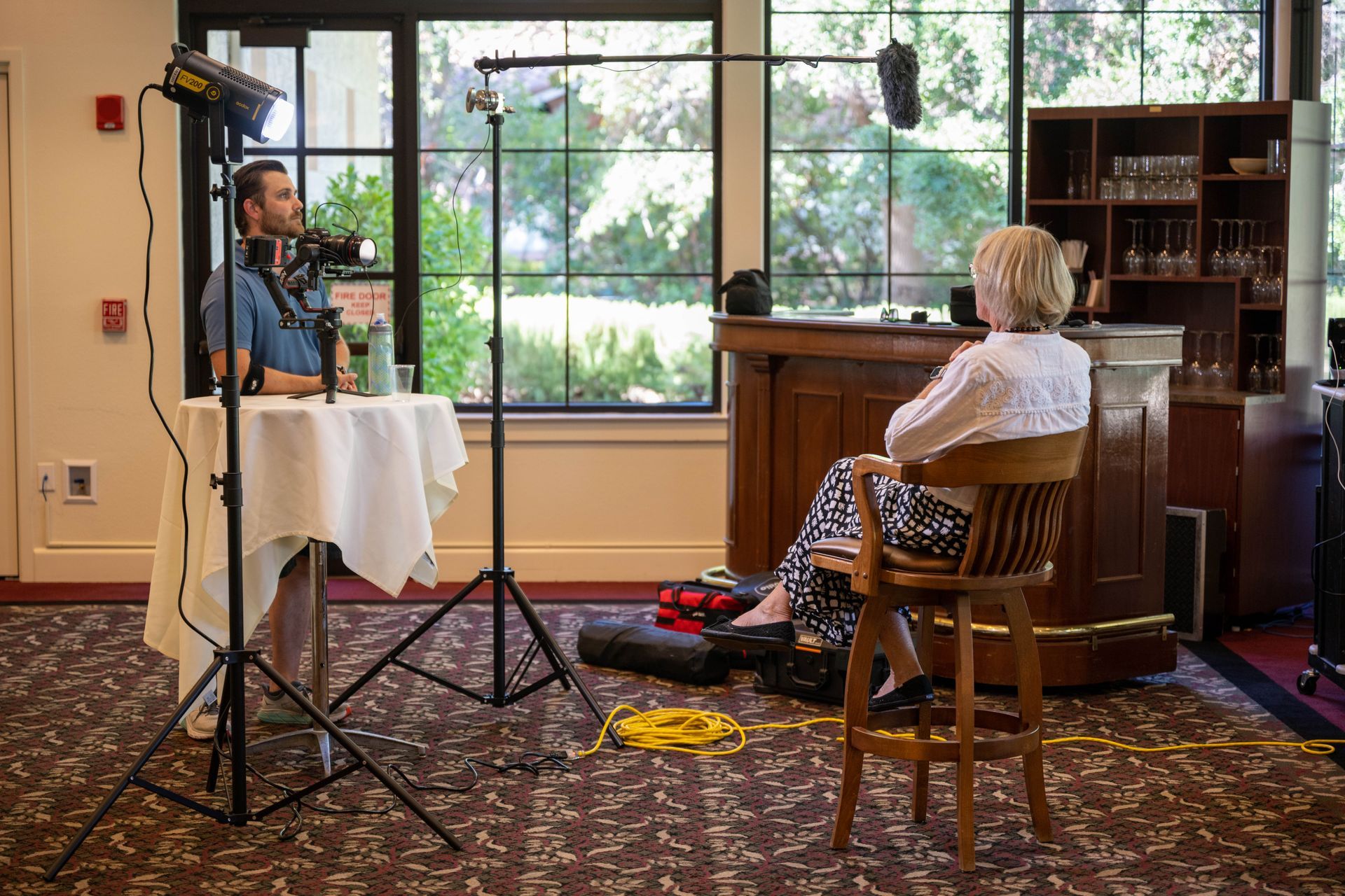 A man is sitting at a table talking to a woman who is sitting in a chair.