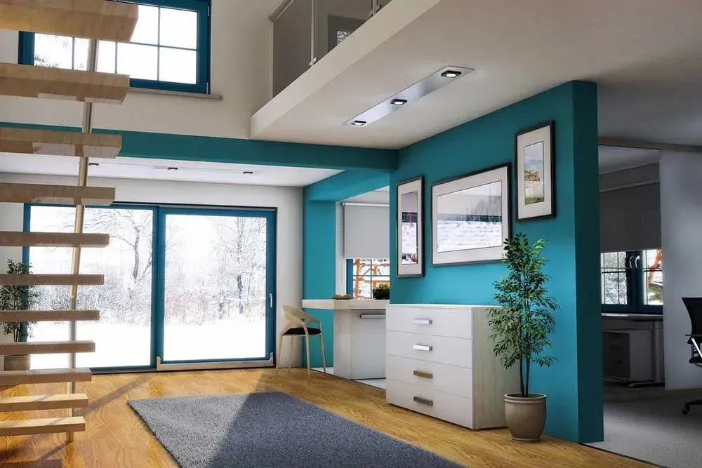 Soggiorno moderno con pareti color verde acqua, ampie finestre, pavimento in legno e una scala in primo piano.