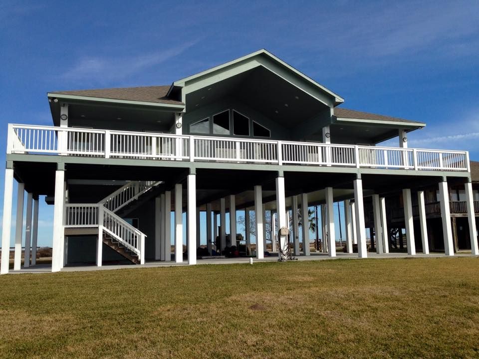 A large house with a large deck and stairs.