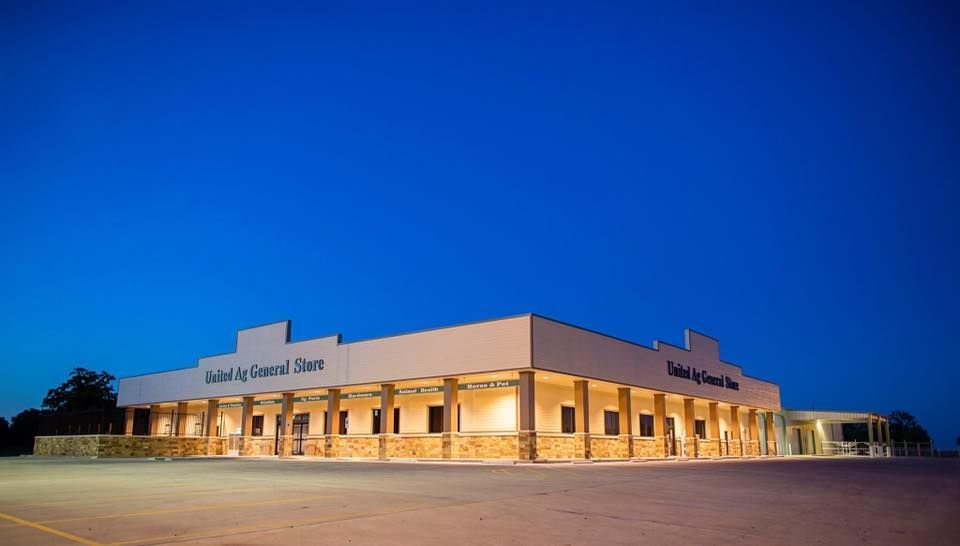 A large white building with a lot of windows is lit up at night.