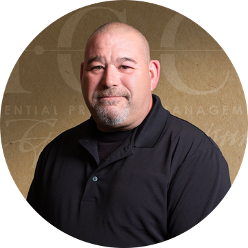 Bald man with a goatee wearing a black polo shirt in front of a neutral backdrop.