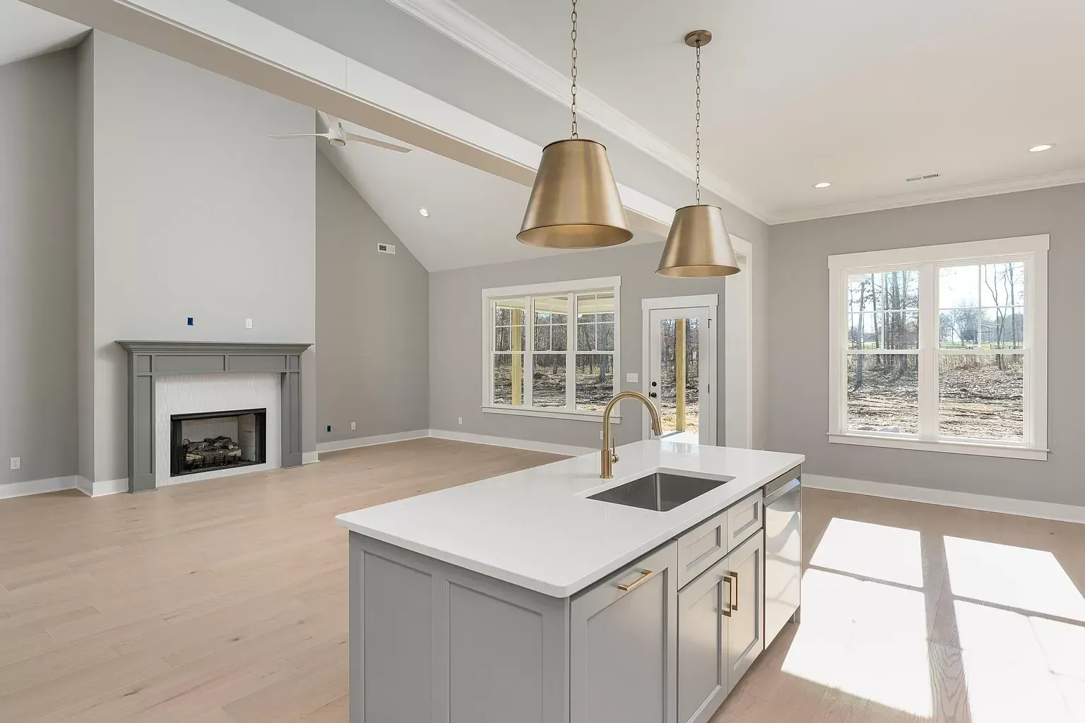 a kitchen with a sink and a fireplace in the background