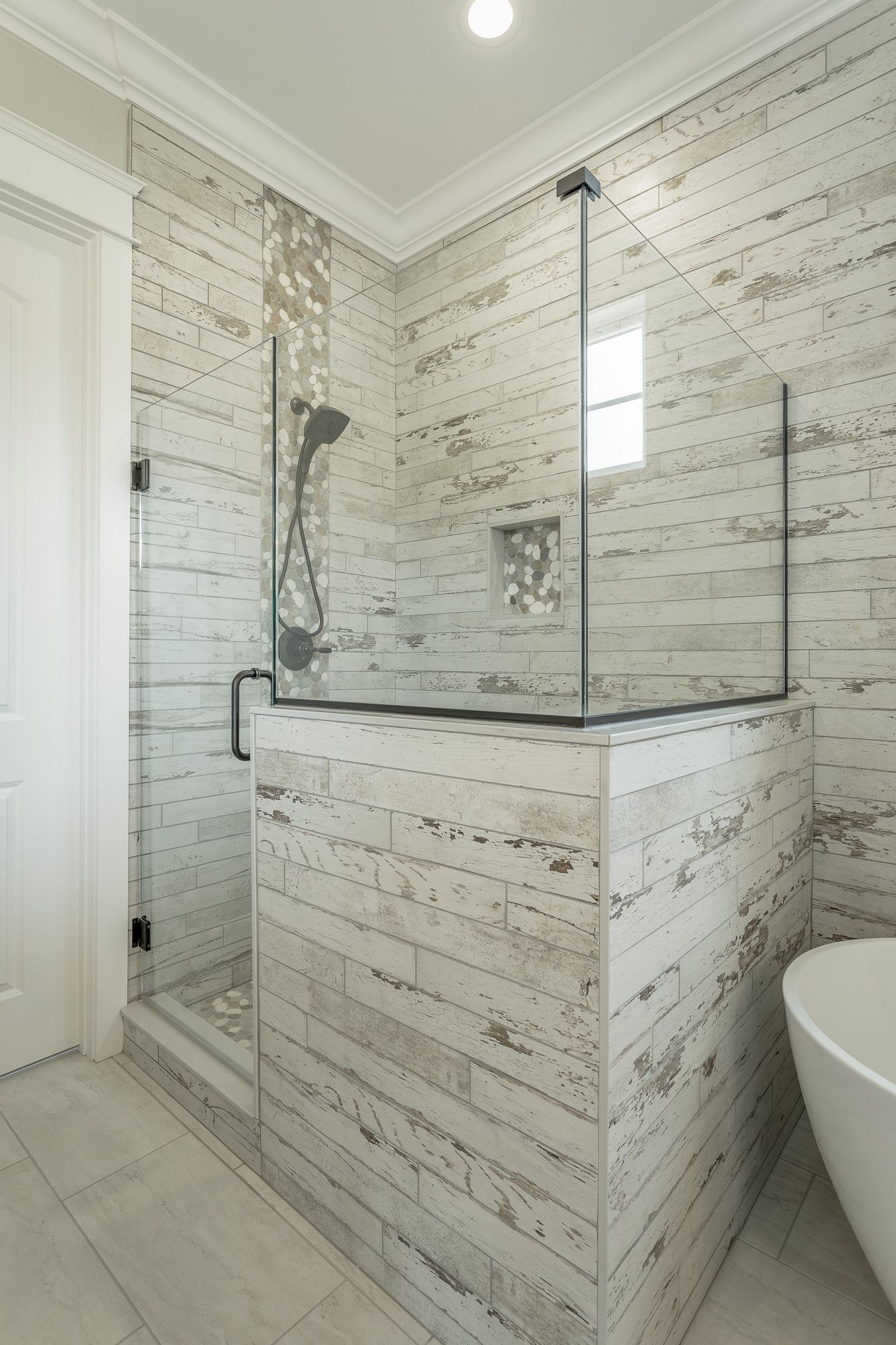 a bathroom with white tiles and a walk in shower