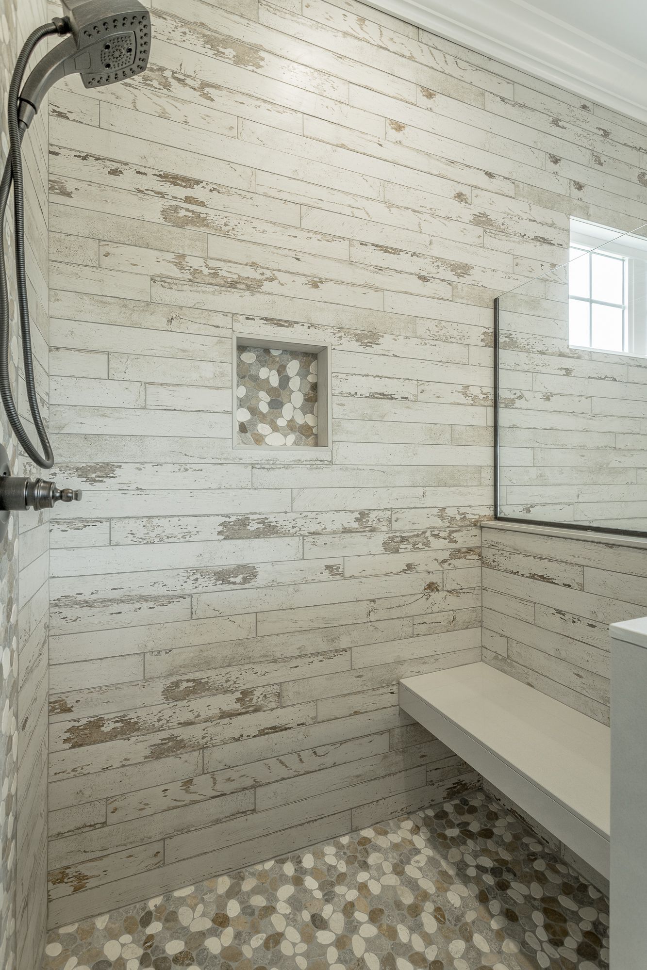 a shower with a bench and a shower head