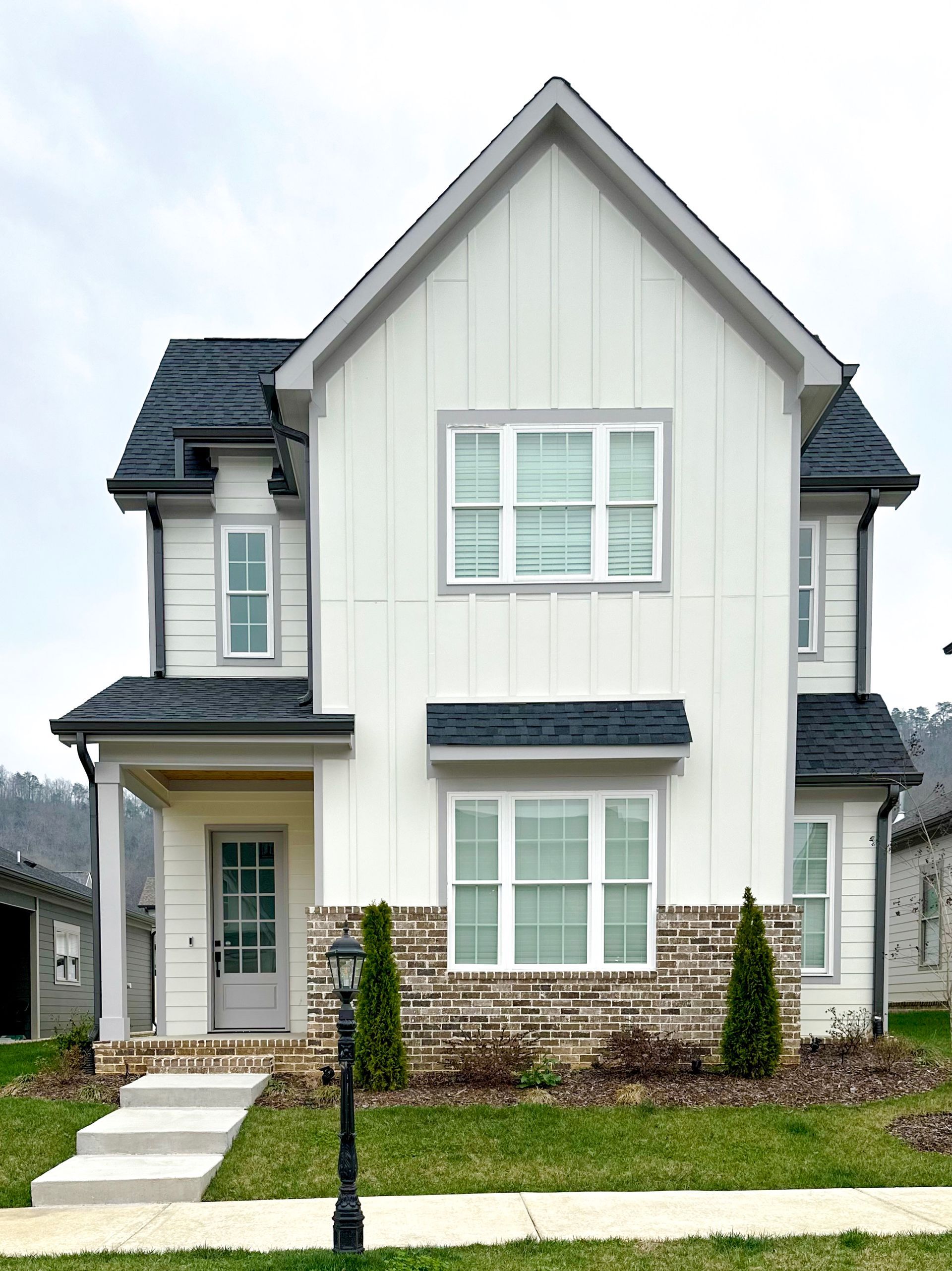 a white house with a black roof and a white door