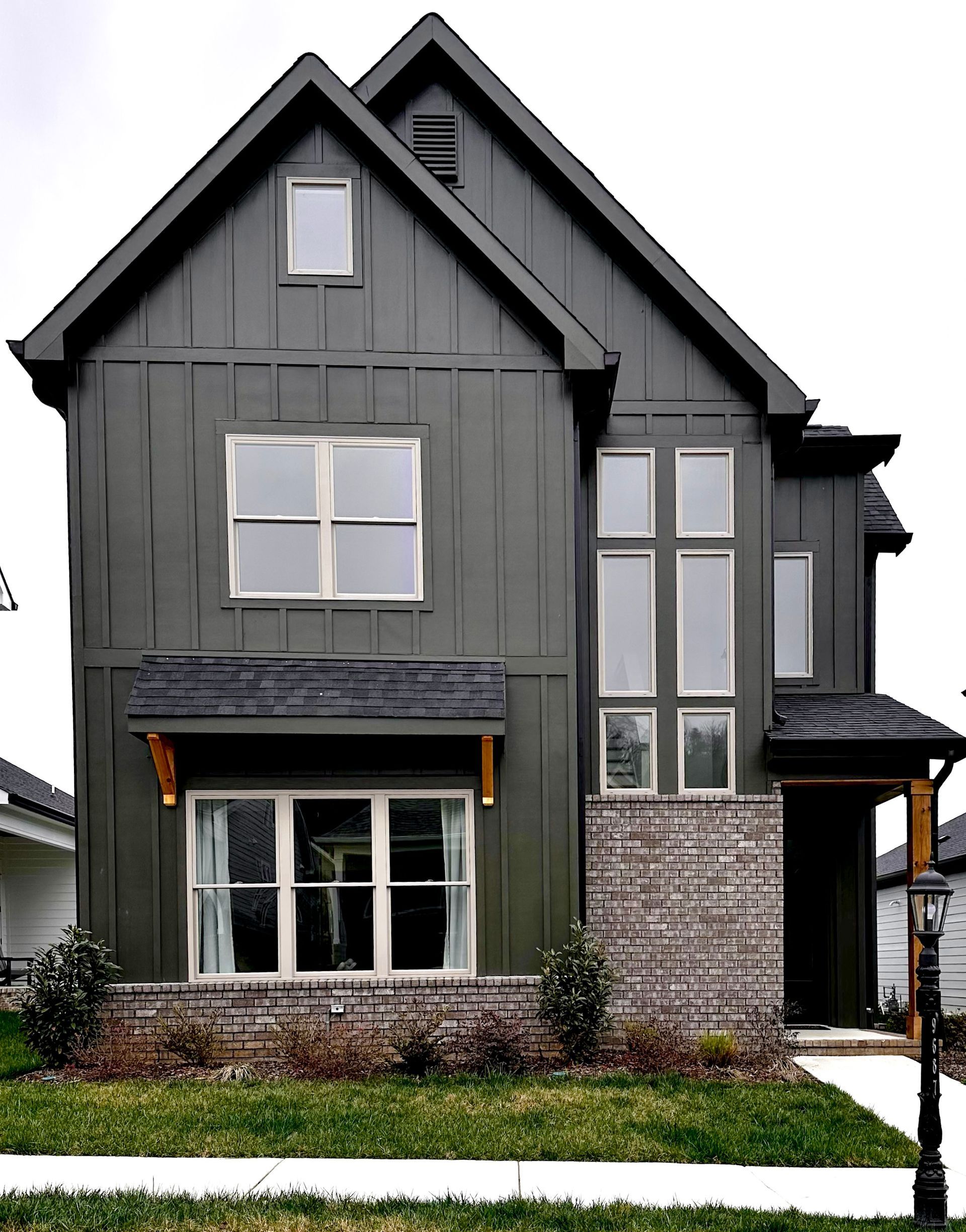 a house with a green siding and a black roof