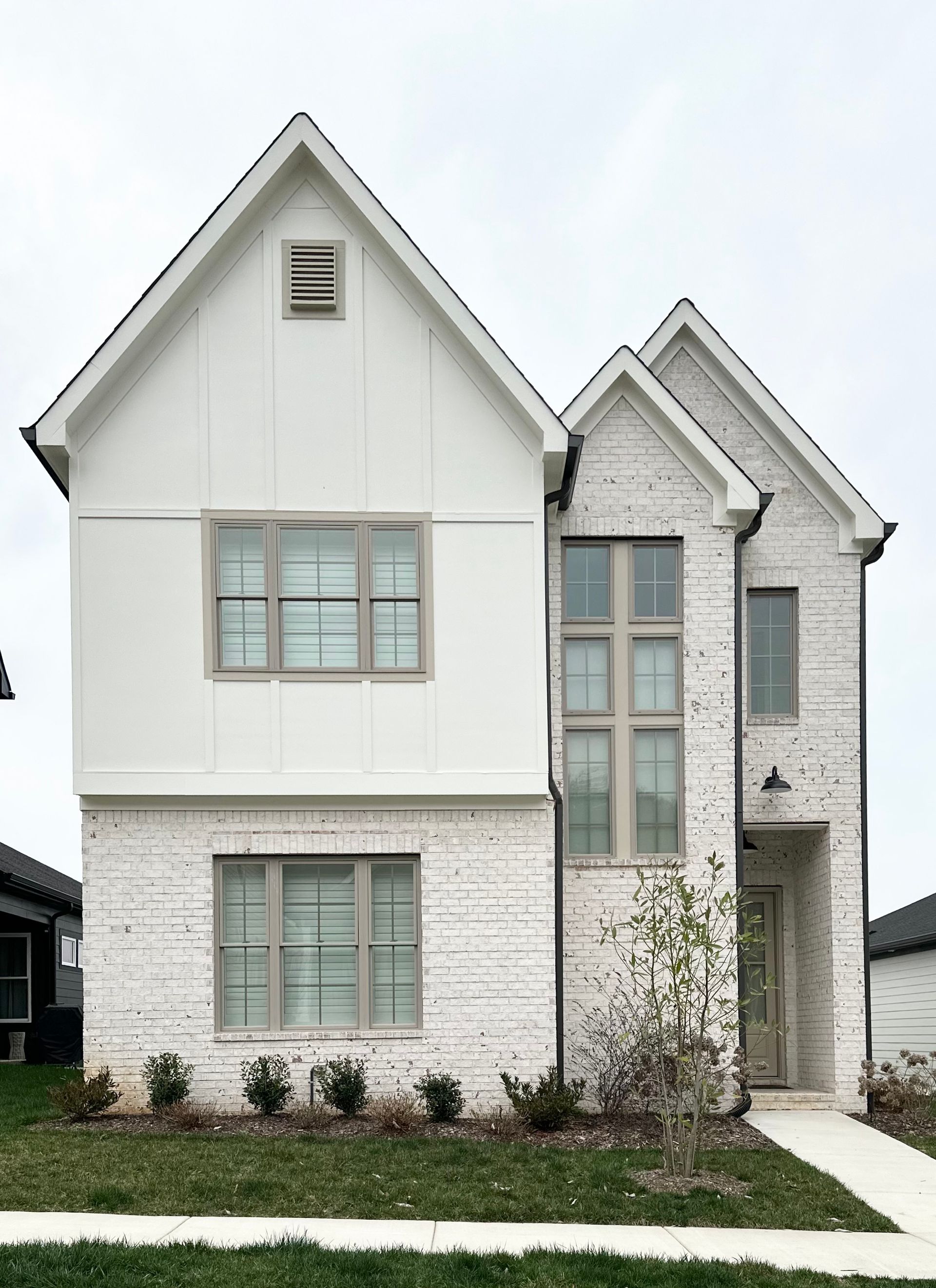 a white brick house with a large roof