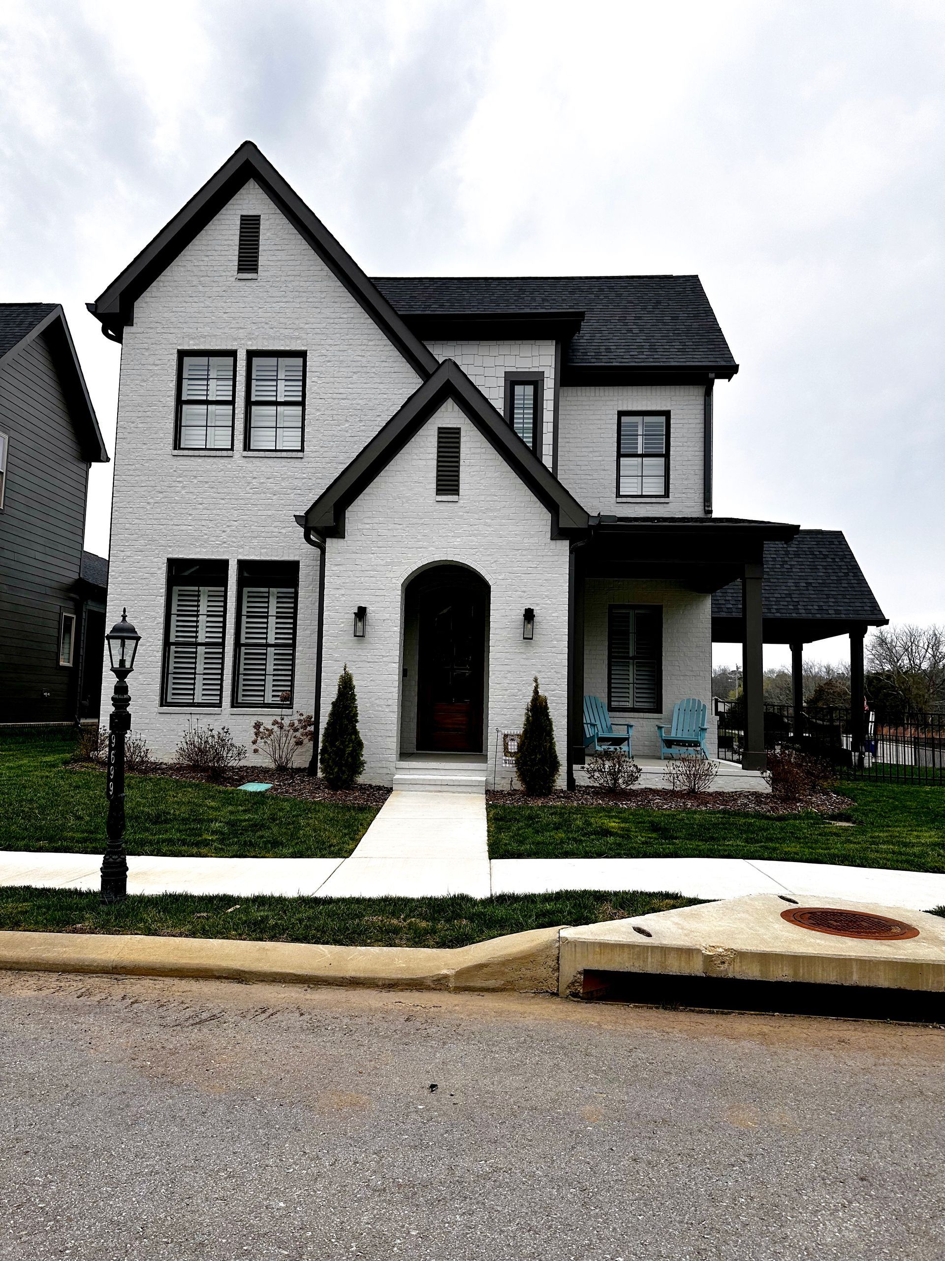 a white brick house with black trim and a black roof
