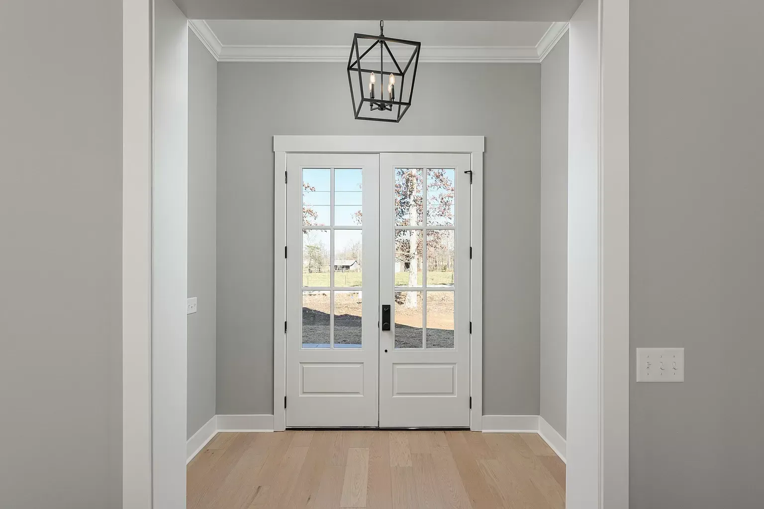a hallway with a white door and a light hanging from the ceiling