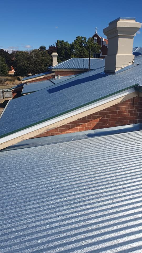 Corrugated Metal Roofs and Brick Building With Chimneys — The Roofer Troopers (NSW) in Howlong, NSW