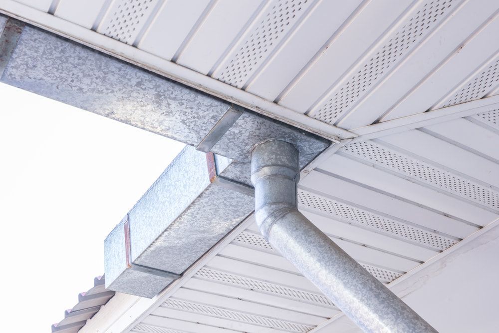 Silver Metal Gutter and Downspout Attached to a White Soffit — The Roofer Troopers (NSW) in Howlong, NSW