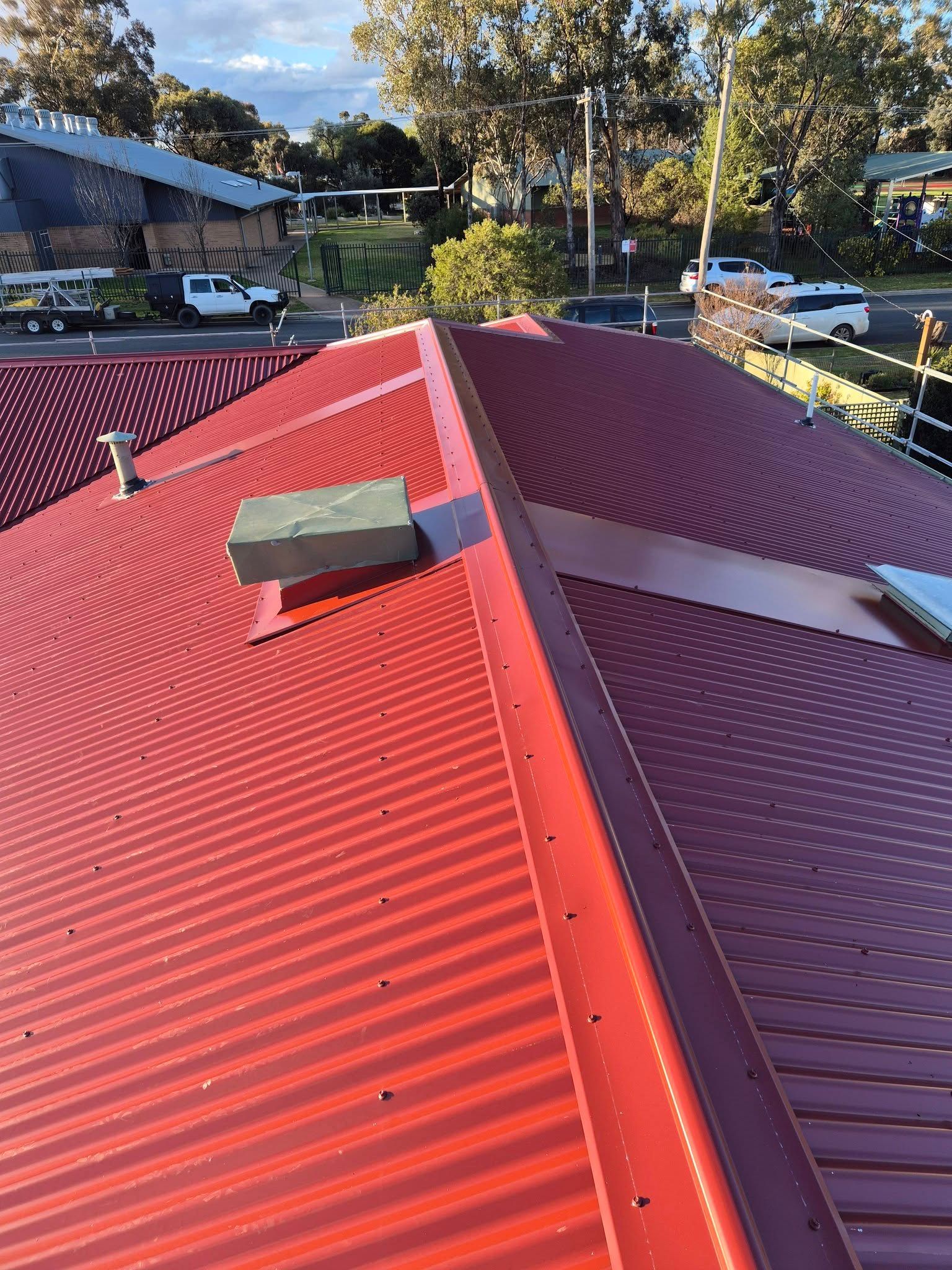 Red Corrugated Metal Roof With Ridge Cap and Vents — The Roofer Troopers in Wodonga, VIC