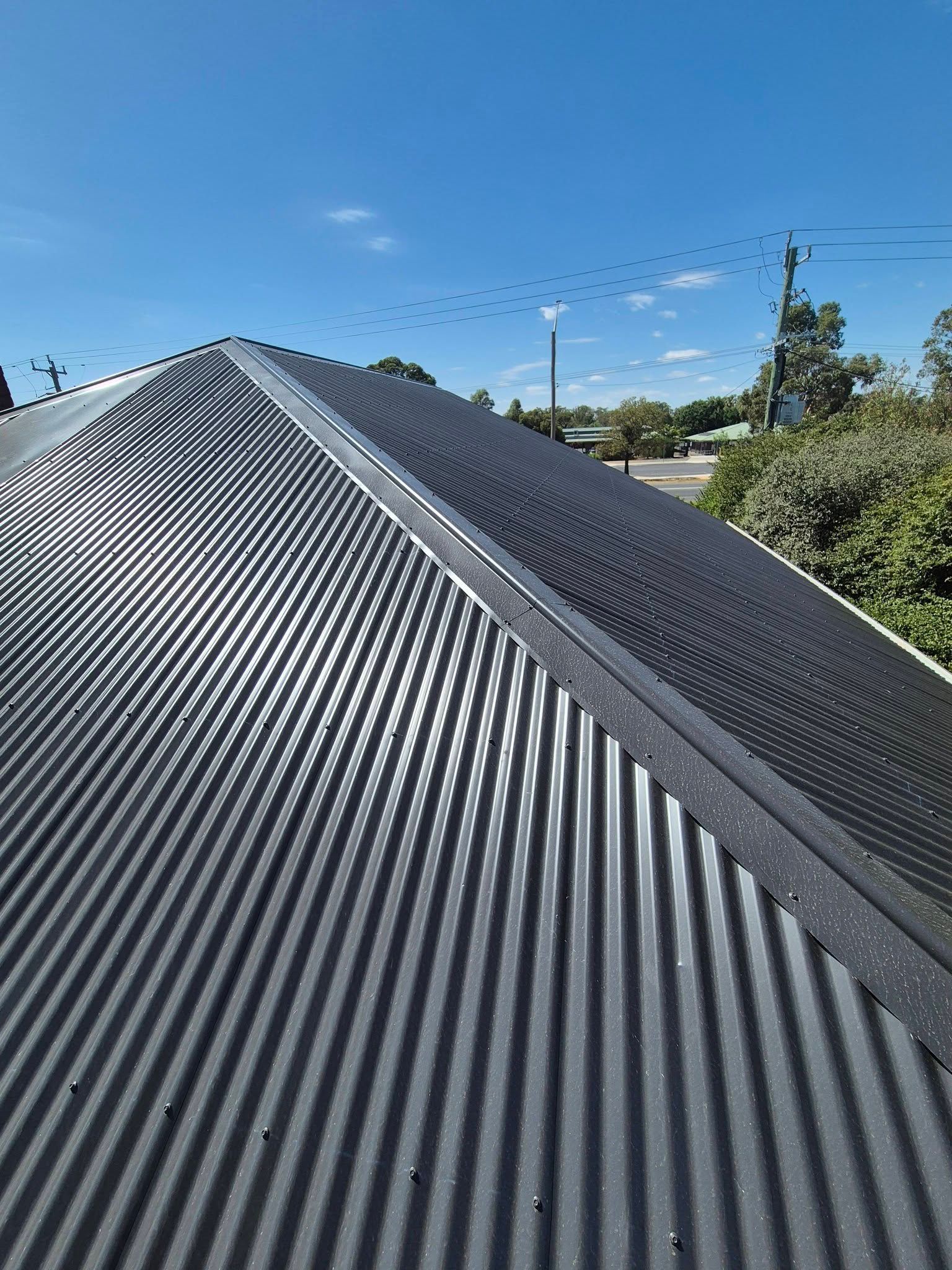 Corrugated Metal Roof Under a Clear Blue Sky — The Roofer Troopers in Wodonga, VIC