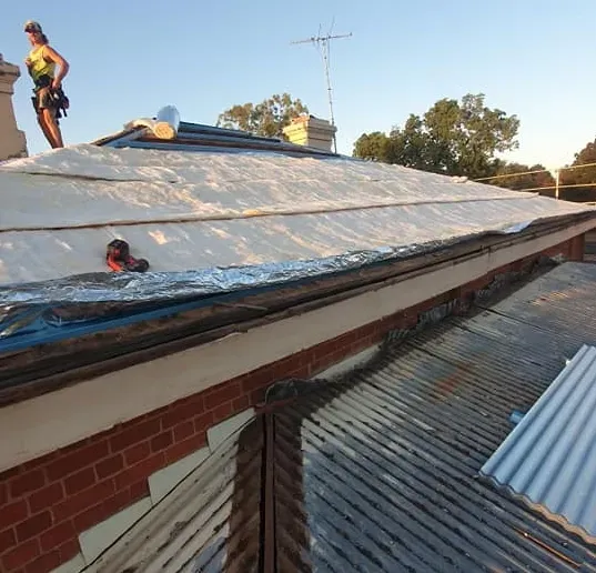 A Man Standing on a Roof Undergoing Roof Maintenance — The Roofer Troopers (NSW) in Rutherglen, VIC