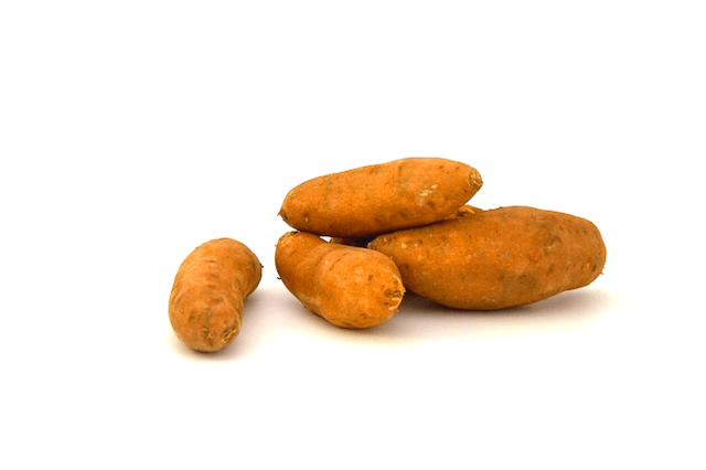 A pile of sweet potatoes on a white background