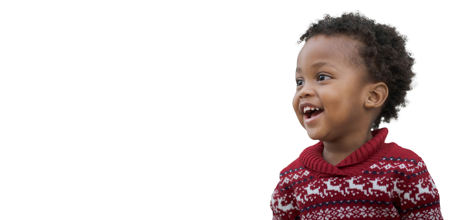 A little boy is wearing a red sweater and smiling.