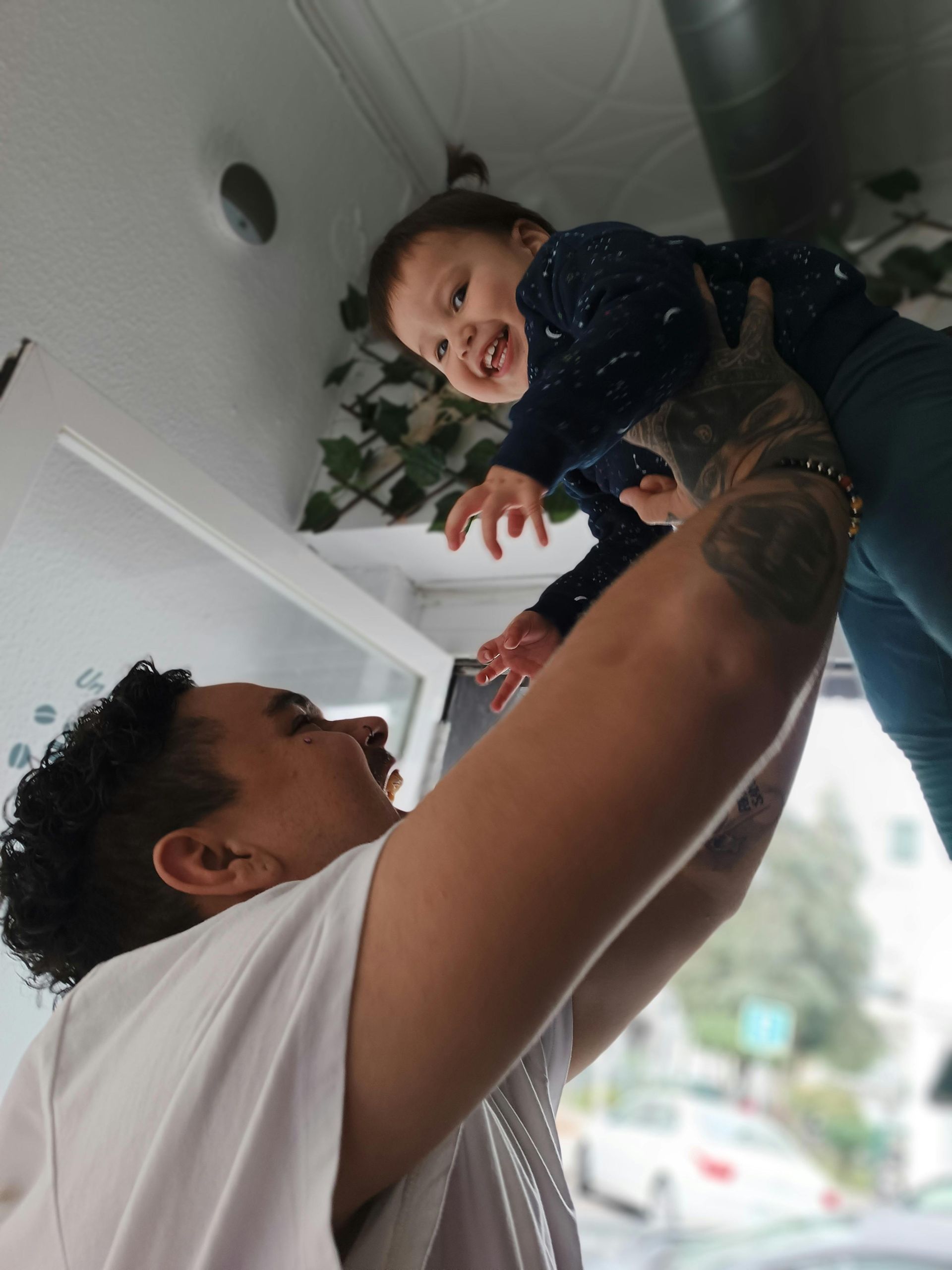 A man is holding a baby up in the air.