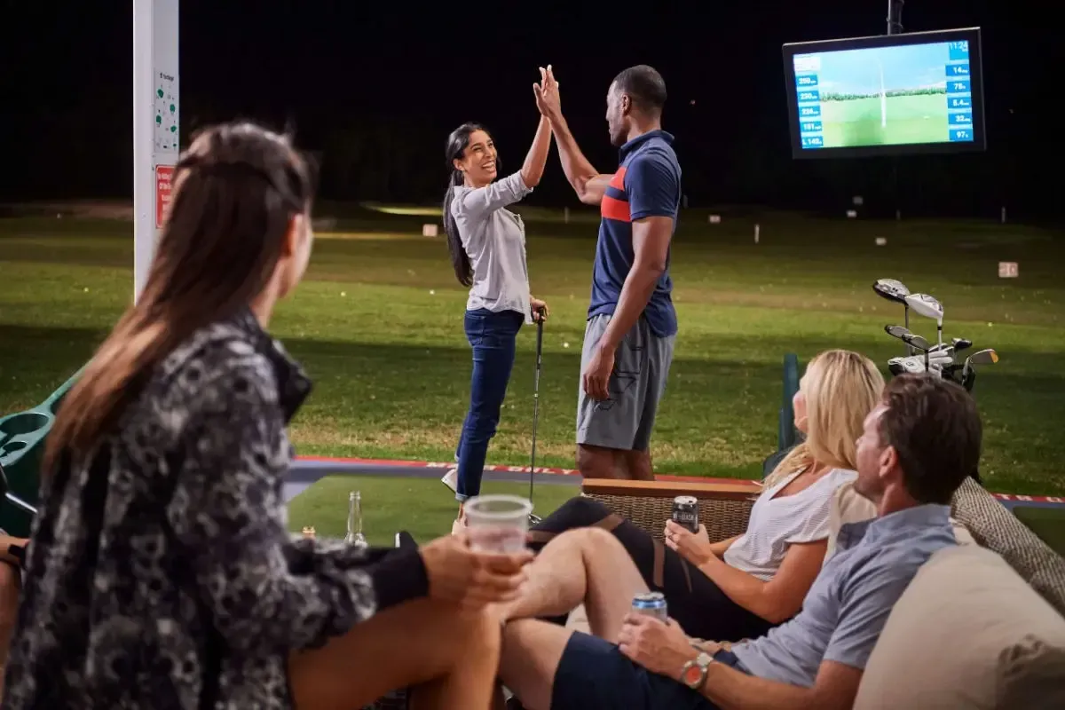 A group of people are giving each other a high five at a golf course.