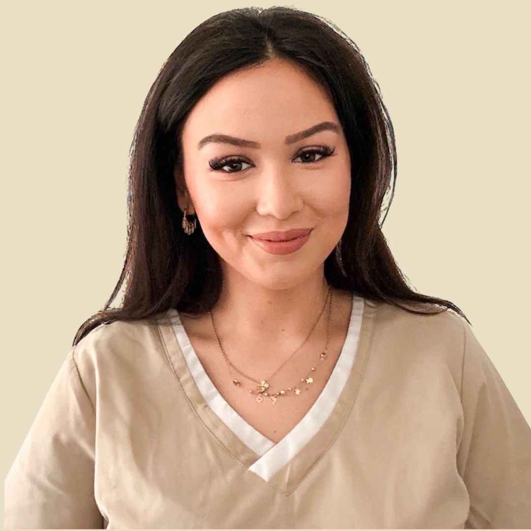 Foto Teammitglied Frau in beigefarbener Kasack, lächelnd, in einem runden Rahmen vor neutralem Hintergrund.