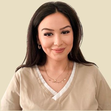 Frau in beigefarbener Kasack, lächelnd, in einem runden Rahmen vor neutralem Hintergrund.