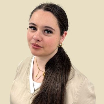 Frau in beigefarbener Kasack, lächelnd, in einem runden Rahmen vor neutralem Hintergrund.