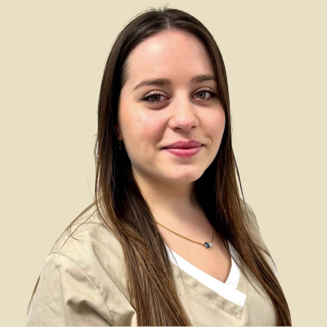 Foto Teammitglied Frau in beigefarbener Kasack, lächelnd, in einem runden Rahmen vor neutralem Hintergrund.