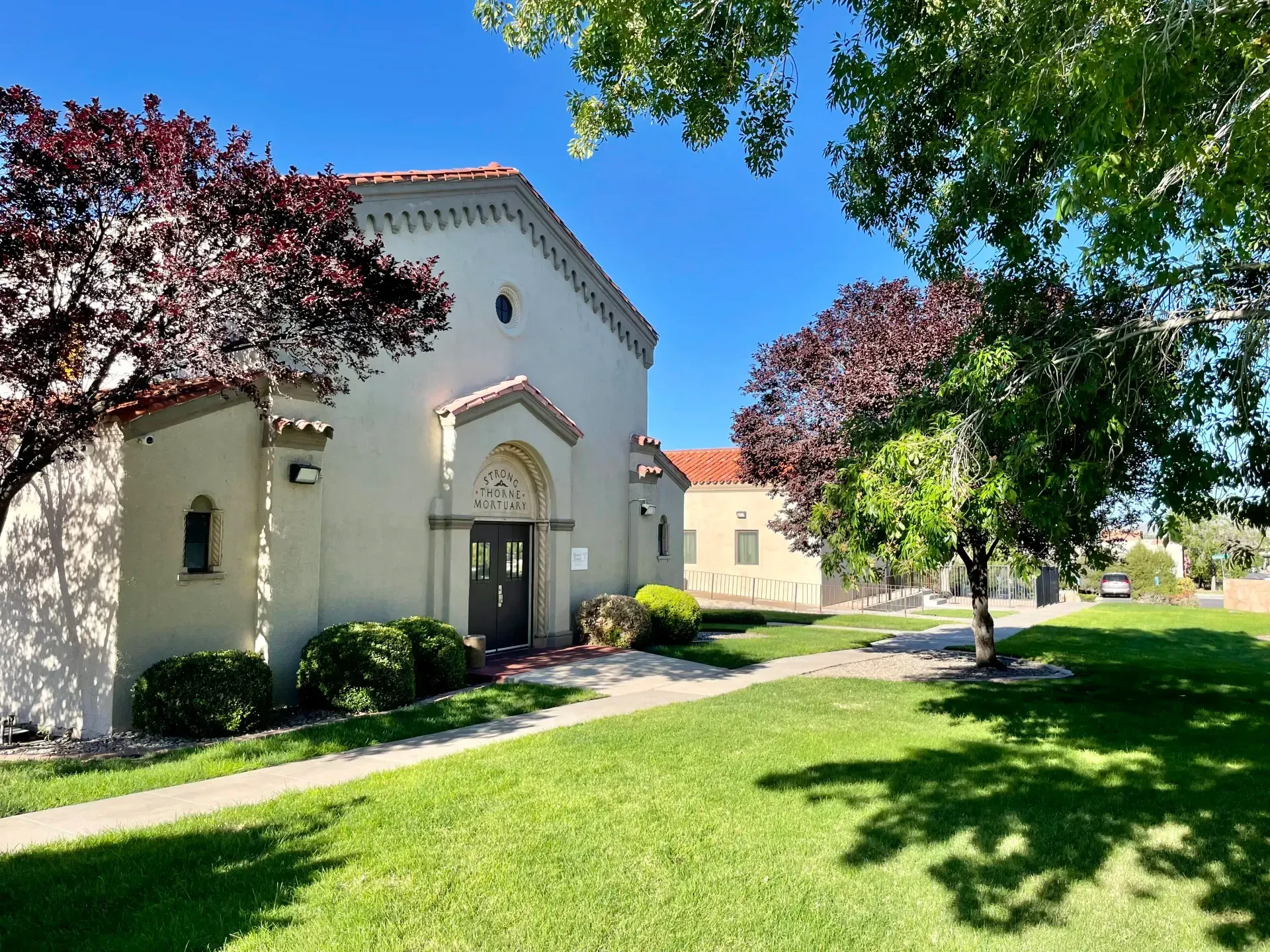 Large foyer with round wooden table, chandelier, and a vase of flowers.