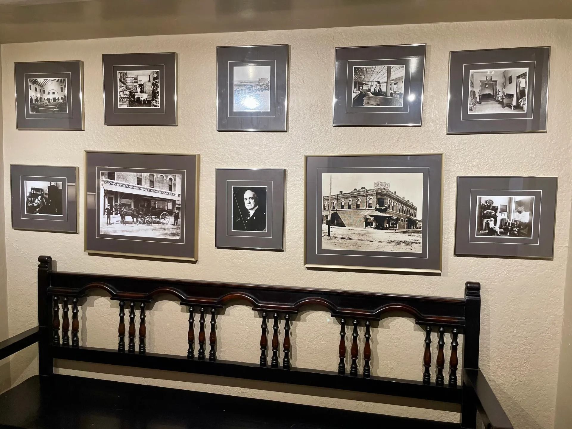 Large foyer with round wooden table, chandelier, and a vase of flowers.