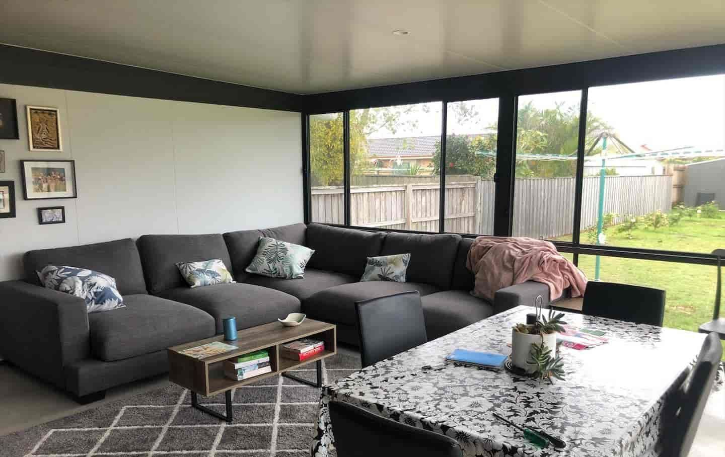 A Living Room With A Couch, Table And Chairs — Caprice Home Additions In Taree, NSW