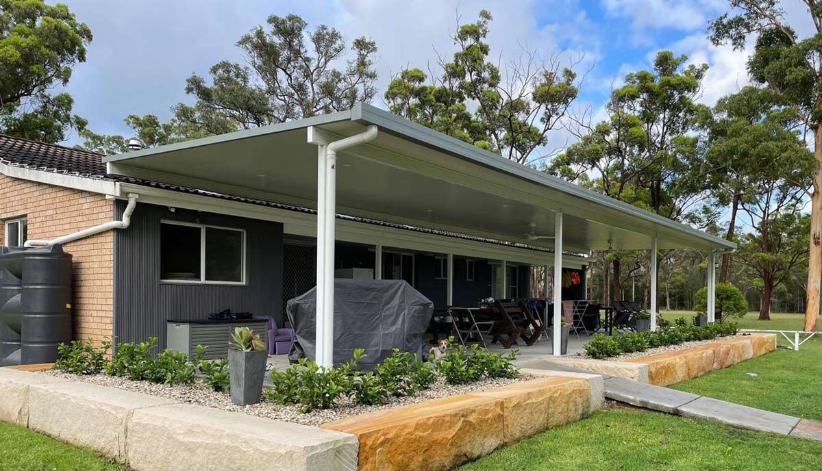 A House With A Covered Porch And A Water Tank — Caprice Home Additions In Forster, NSW