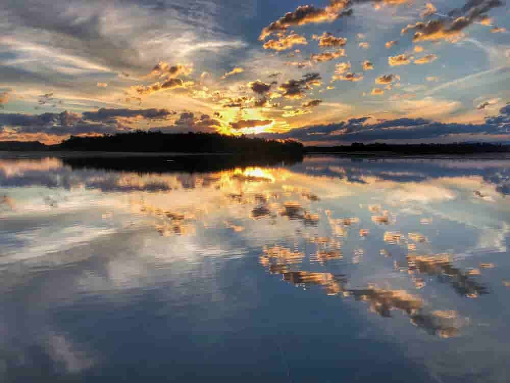 A Sunset Over A Lake With Clouds Reflected In The Water — Caprice Home Additions In Old Bar, NSW