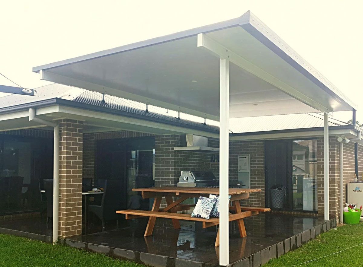 A House With A Covered Porch And A Picnic Table In Front Of It — Caprice Home Additions In Taree, NSW