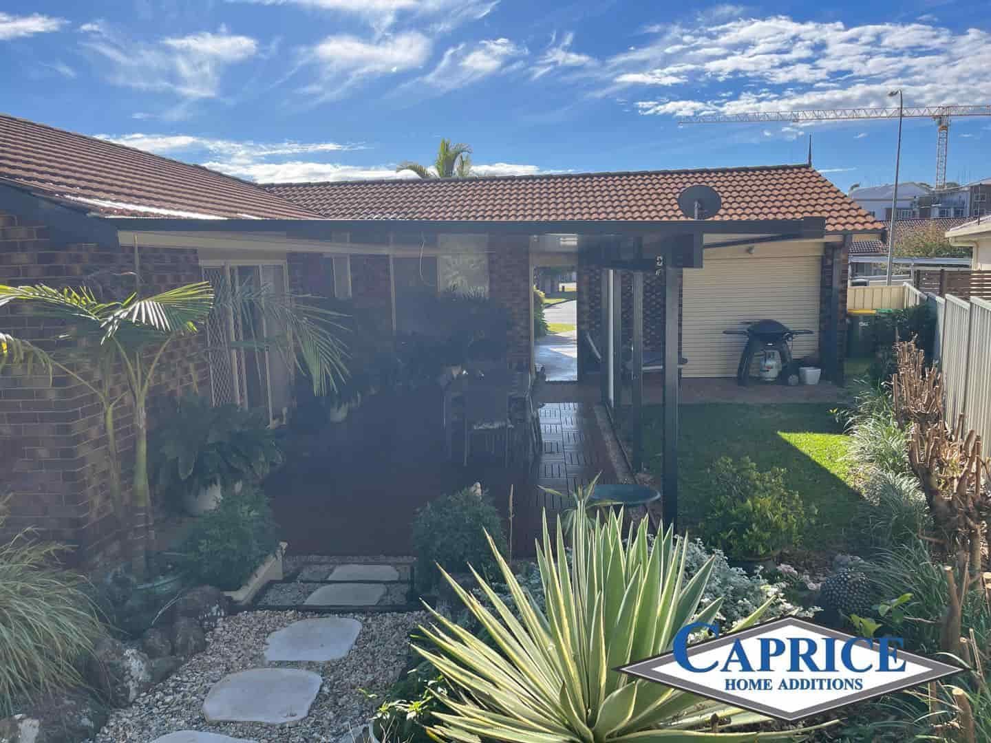 A House With A Red Tile Roof And A Walkway Leading To It — Caprice Home Additions In Taree, NSW