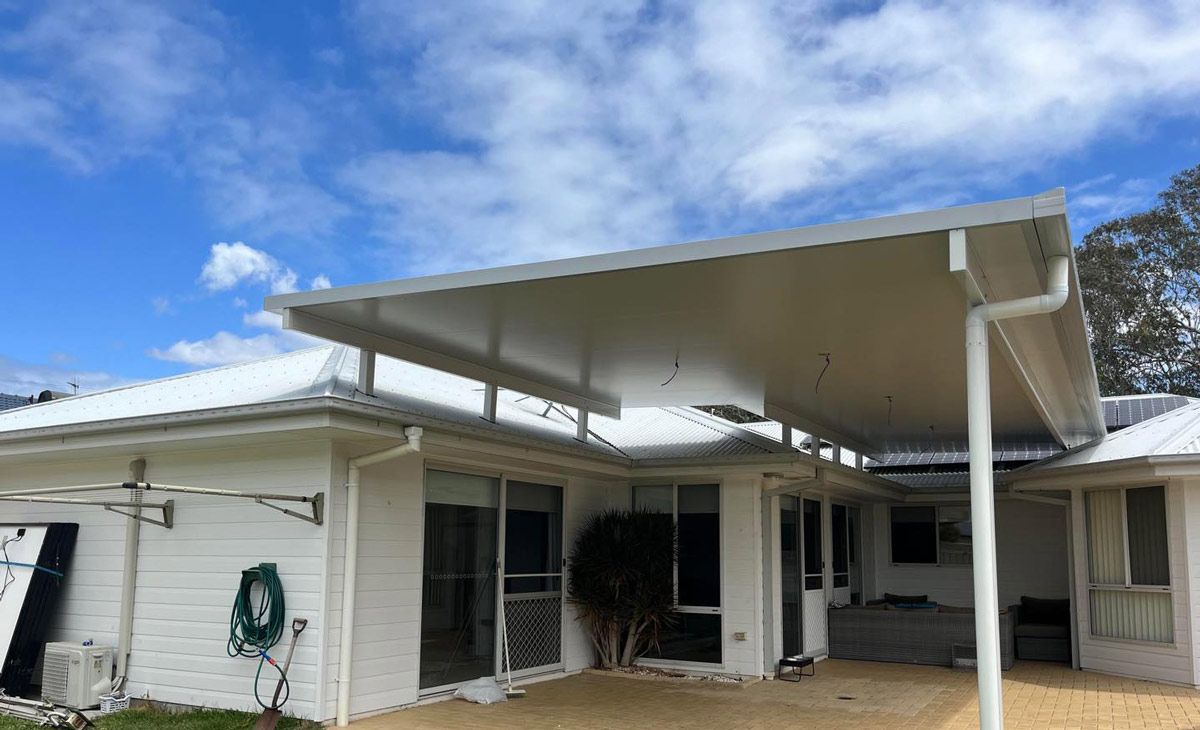 A White House With A Covered Carport In Front Of It — Caprice Home Additions In Wingham, NSW