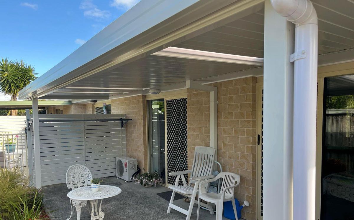 A Patio With A Table And Chairs Under A Canopy — Caprice Home Additions In Taree, NSW