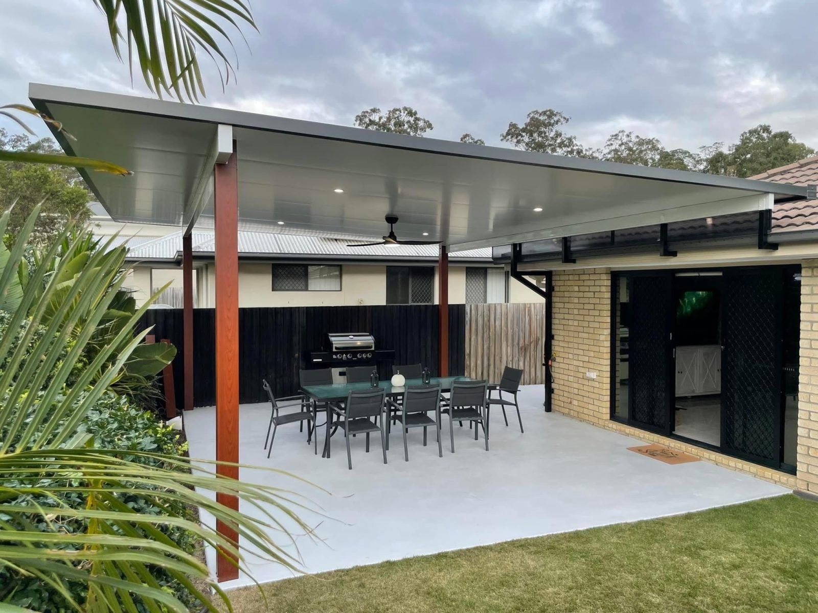 Patio With Gray Concrete, Covered by a Flat Gray Roof — Caprice Home Additions In Taree, NSW