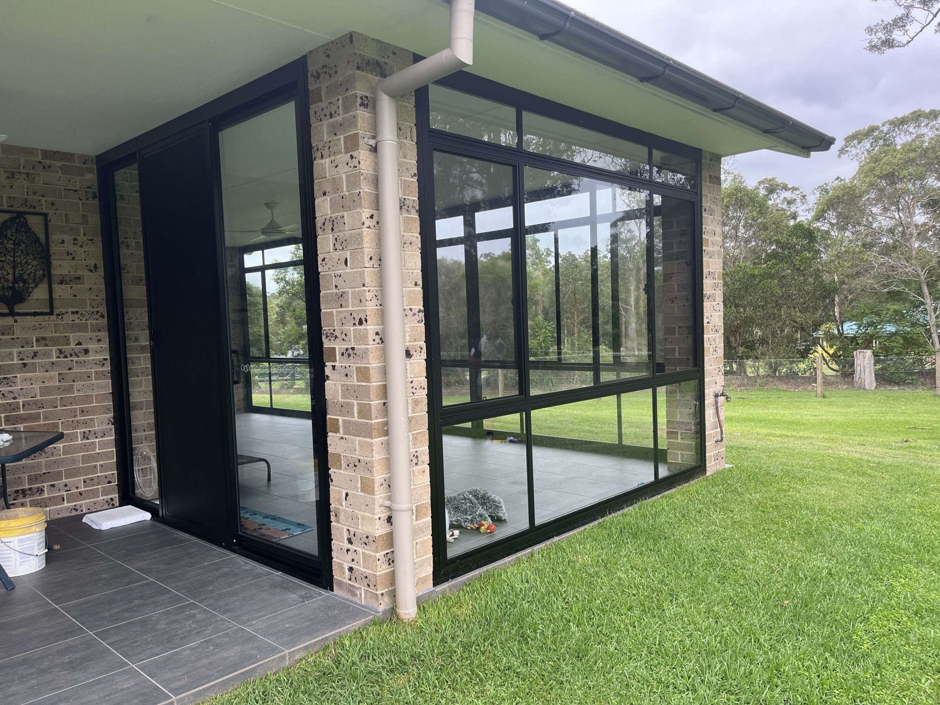 A Brick House With A Large Deck And A White Roof — Caprice Home Additions In Taree, NSW