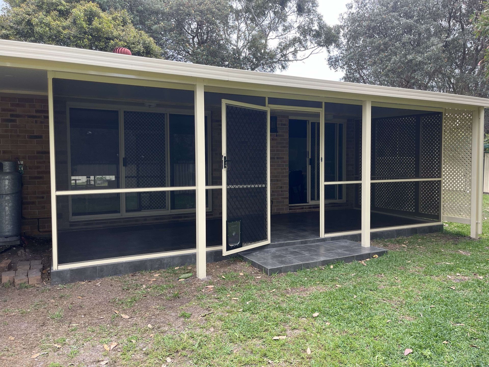 A Brick House With A Screened In Porch — Caprice Home Additions In Taree, NSW