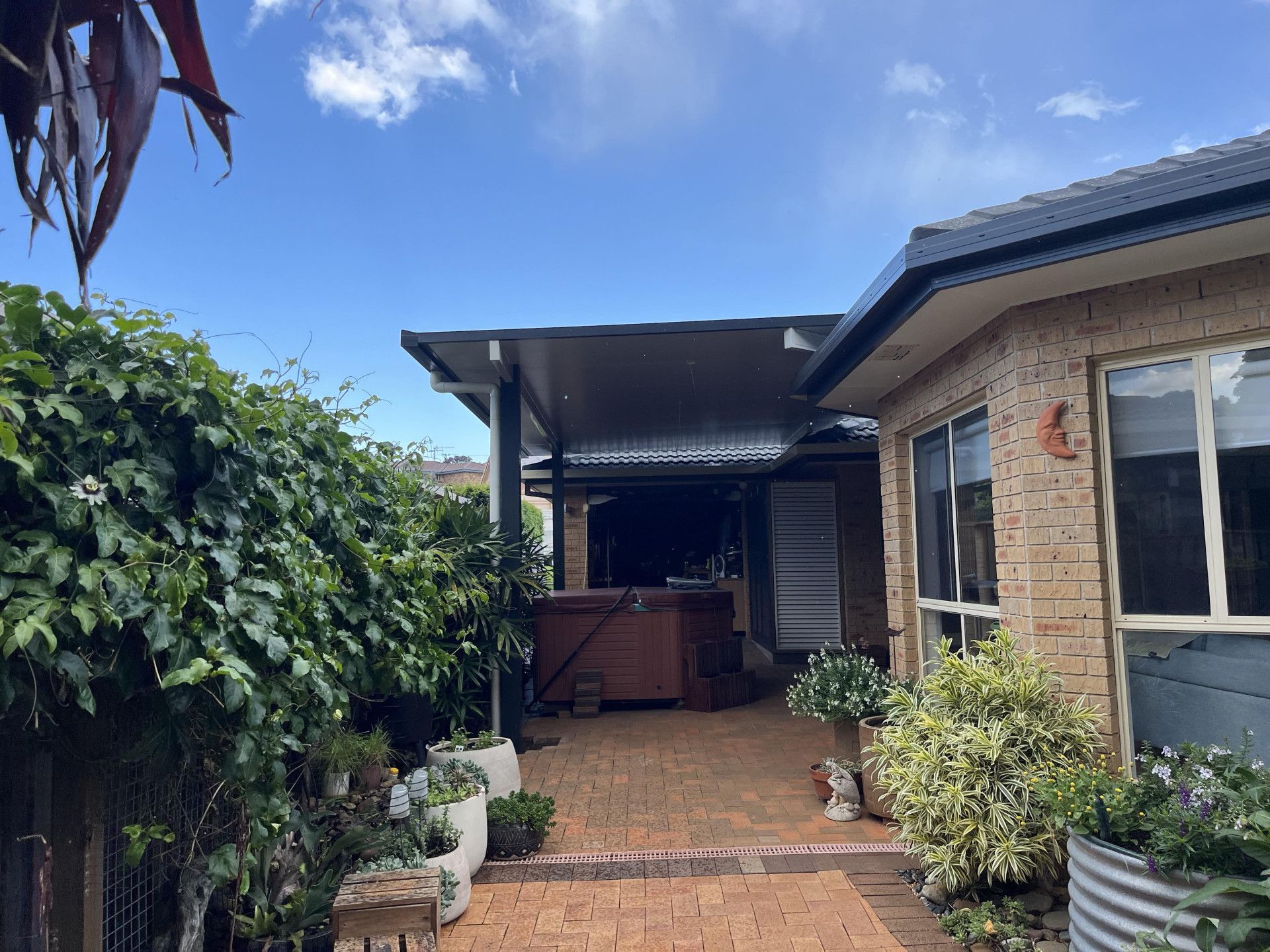 A House With A Spa Bath Under The Porch  Surrounded By Potted Plants — Caprice Home Additions In Taree, NSW