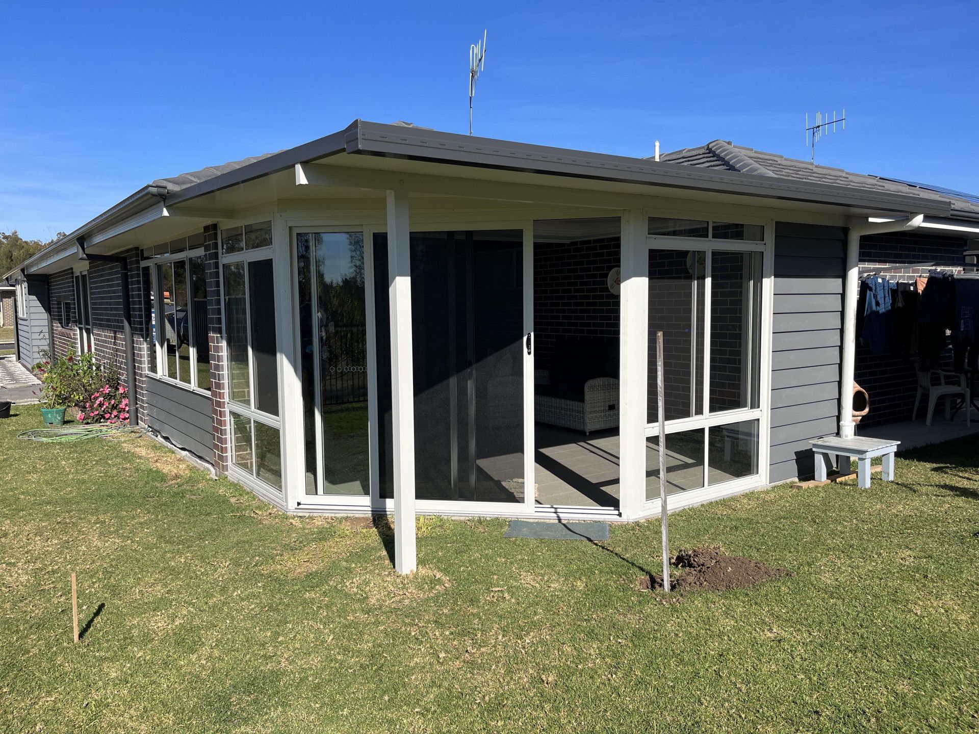 A house with a lot of windows is sitting on top of a lush green lawn. — Caprice Home Additions In Taree, NSW