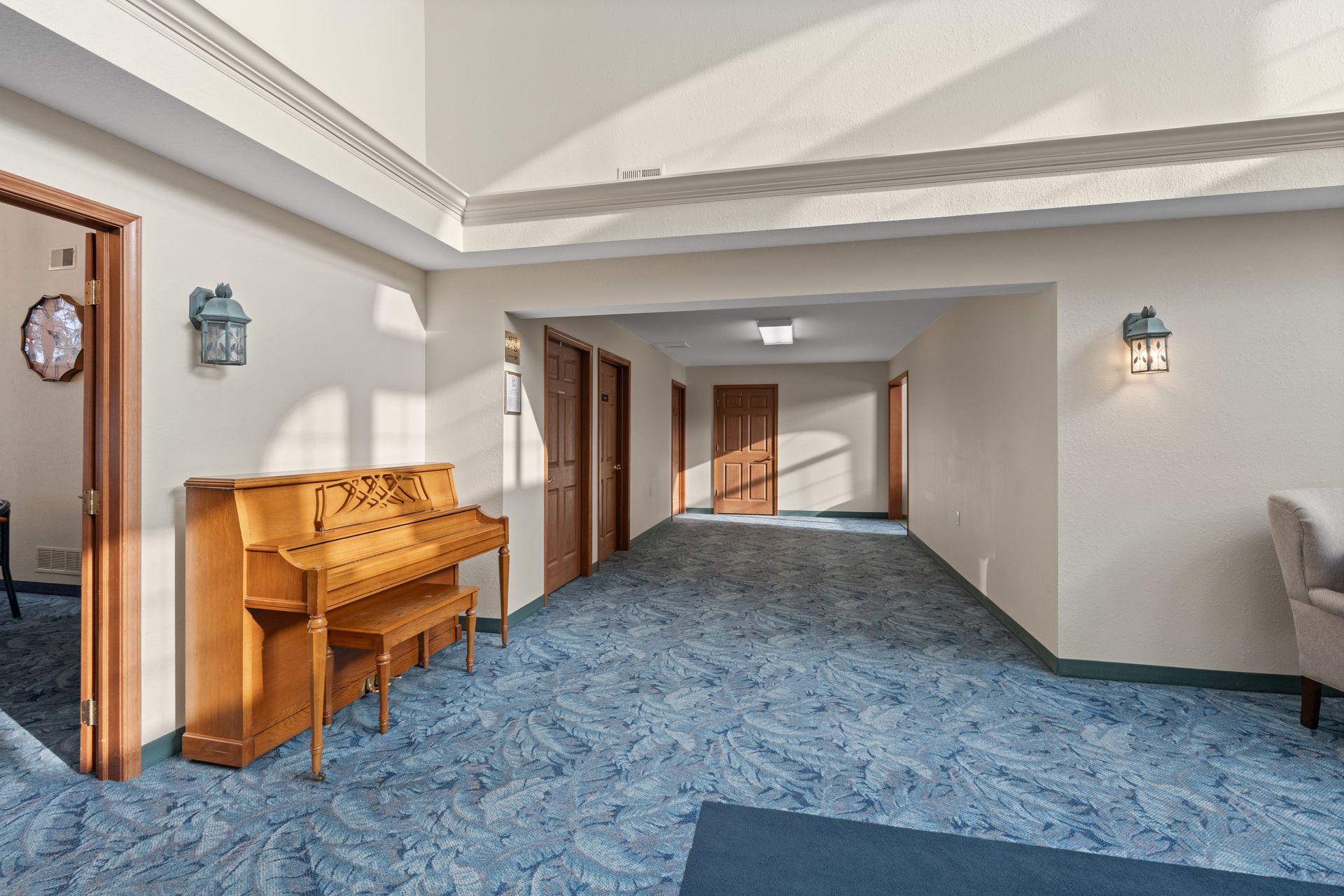 Photo of a wide hallway and the foyer to the great room, with a piano to the side