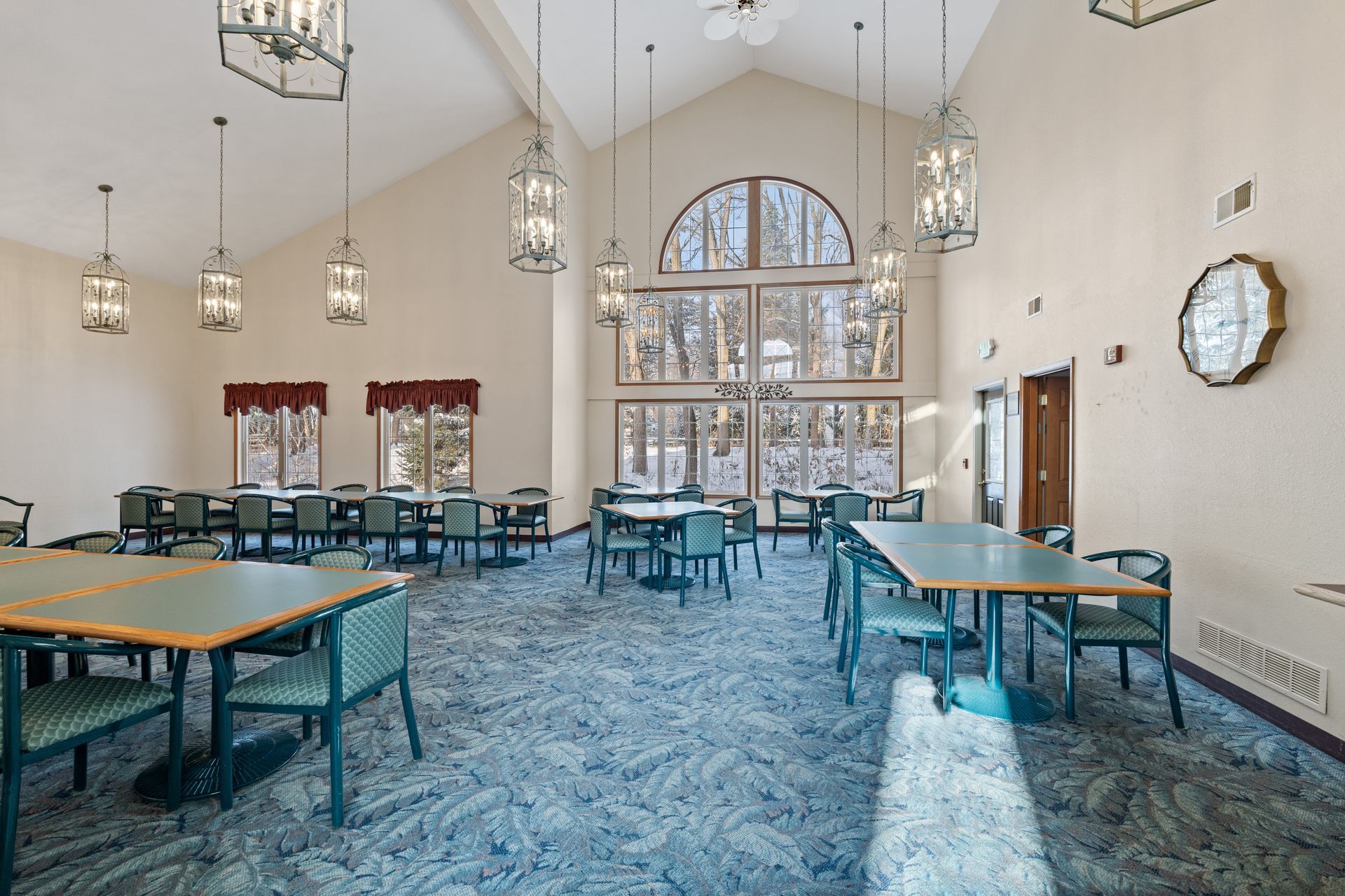 Photo of a large hall with plenty of natural lighting and walking space as well as multiple tables to sit at