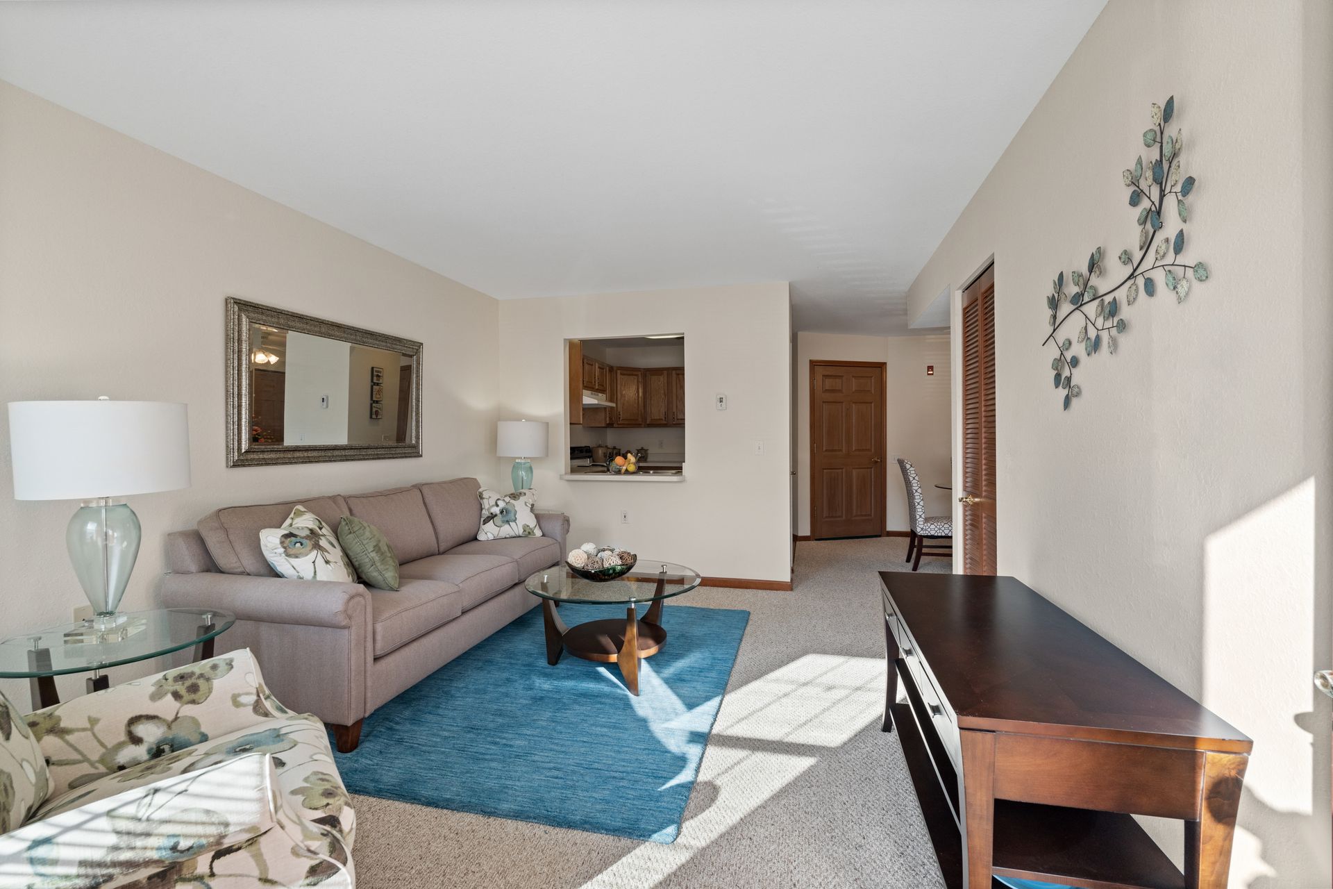 Photo of a living room with the dining room and kitchen in the background