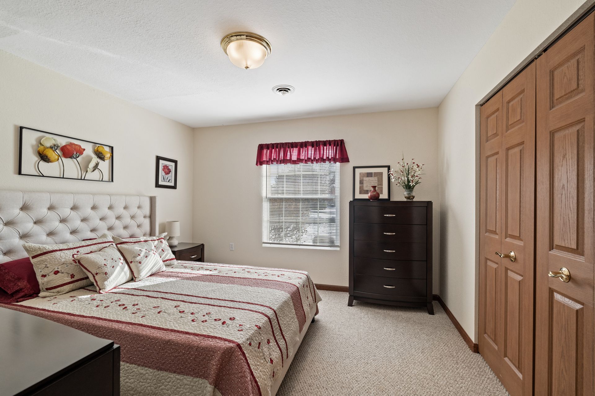 Photo of a bed in a bedroom with double doors to a closet