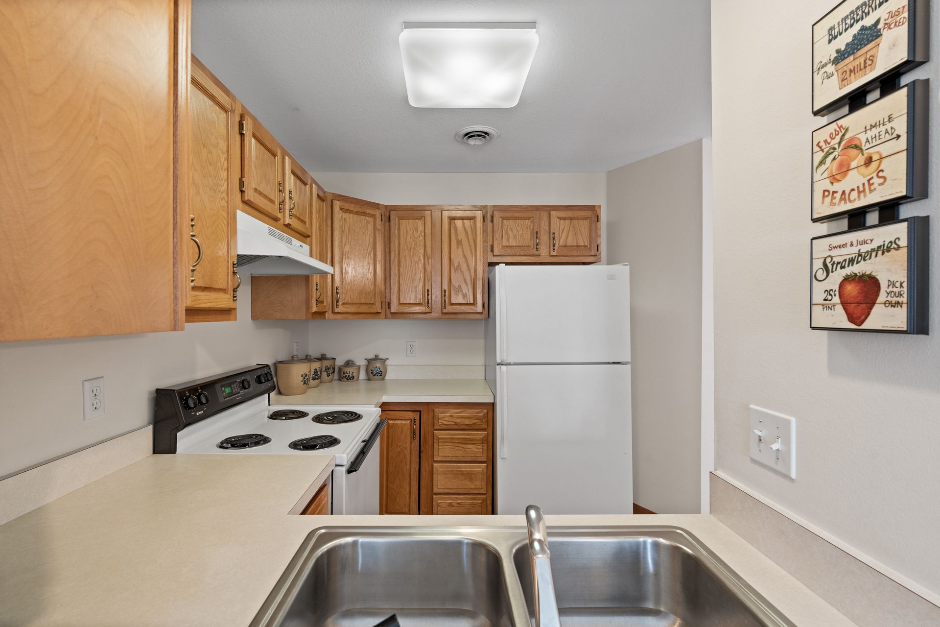 Photo of a kitchen with a refrigerator, stove and plenty of cabinetry