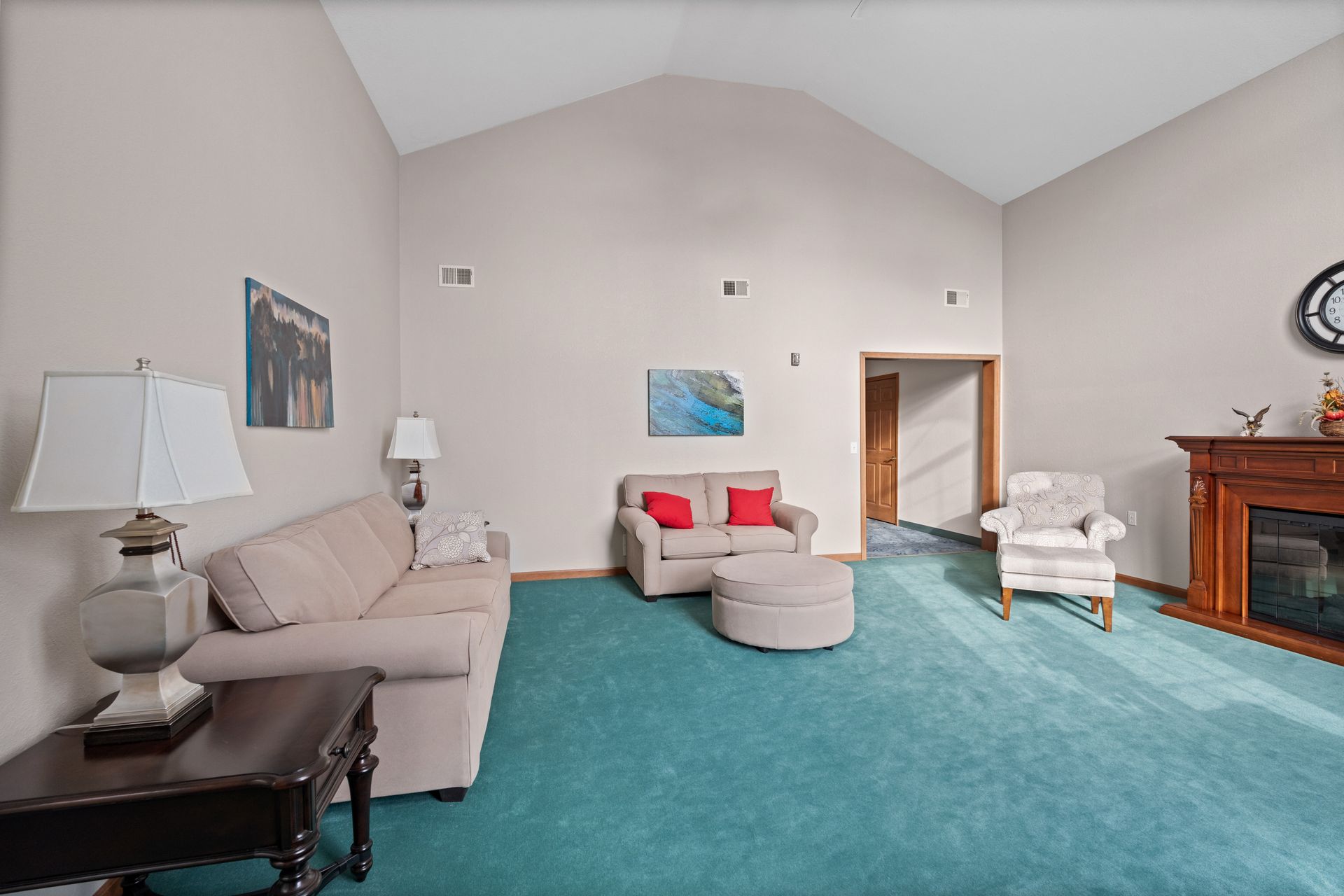 Photo of a parlor with a couch, loveseat and arm chair as well as a fireplace