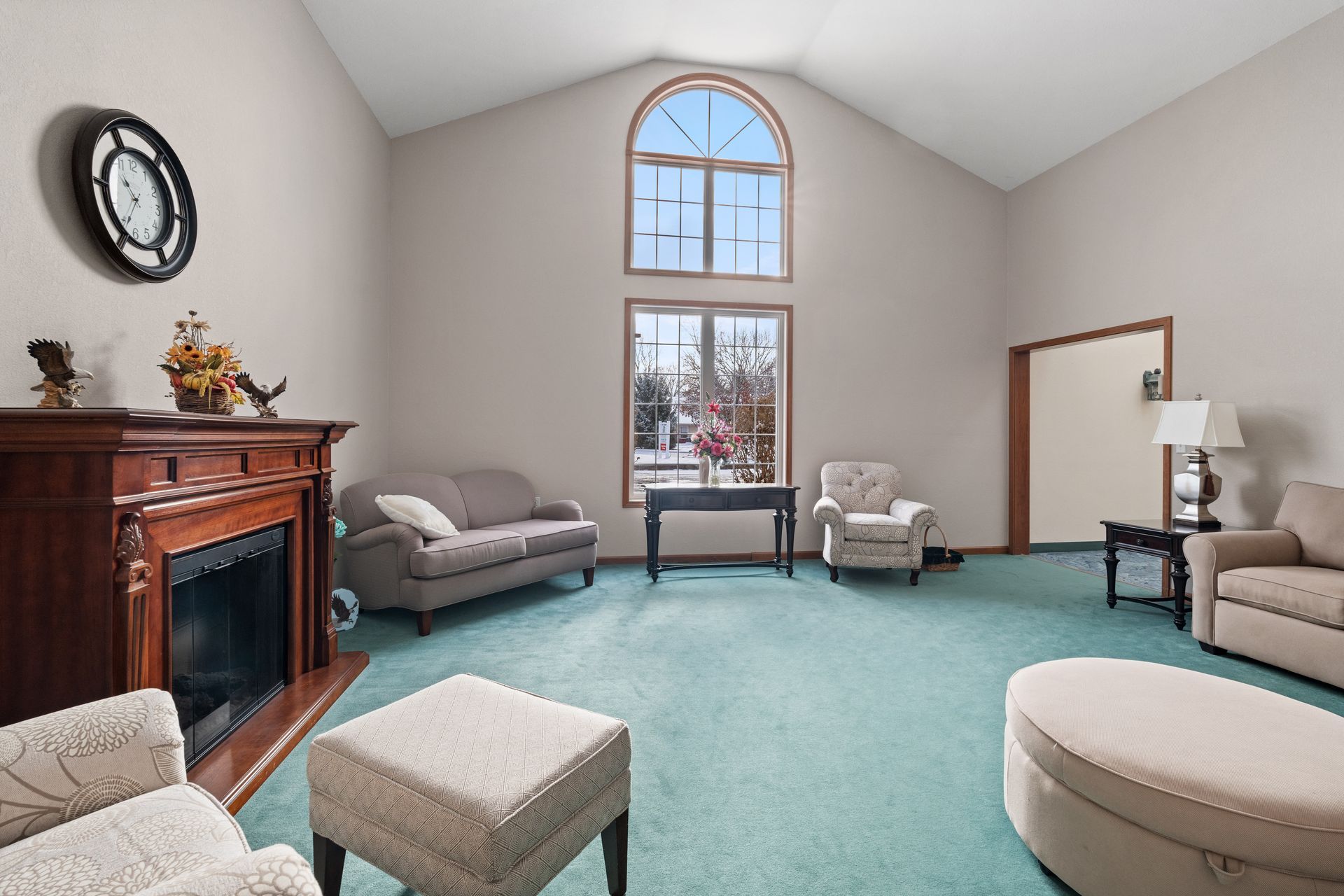 Photo of a parlor with plenty of natural light and seating, as well as a fireplace