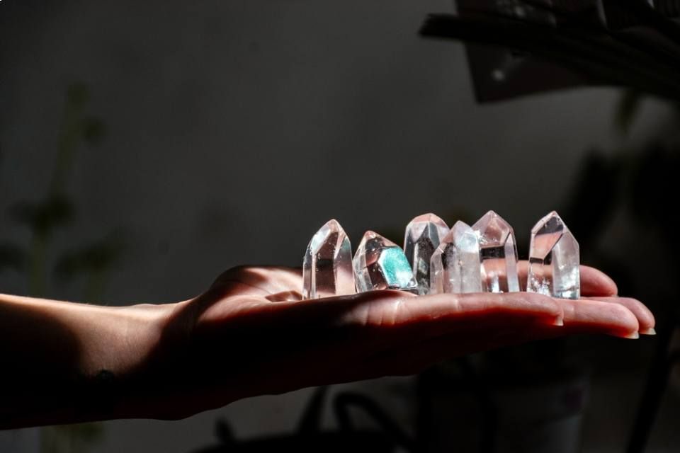 Hands of a sorceress holding healing quartz crystals